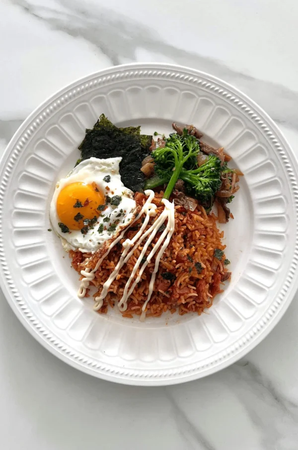 Kimchi Fried Rice with Duck Egg and toasted seaweed in a white plate.