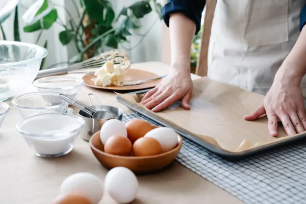 Preparing baking sheet with parchment paper for baking.