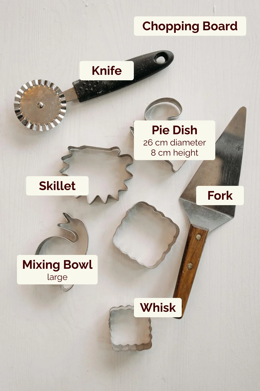 Baking tools: knife, pie dish, whisk, mixing bowl, skillet, fork, board.