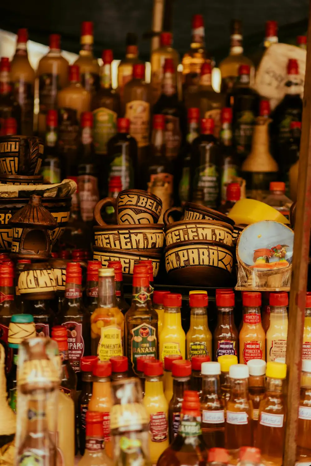 Brazilian market stall with colorful bottles and ceramic cups. "Belem Para" text visible.