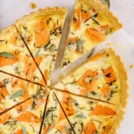 Butternut squash and sage quiche slices on parchment paper.