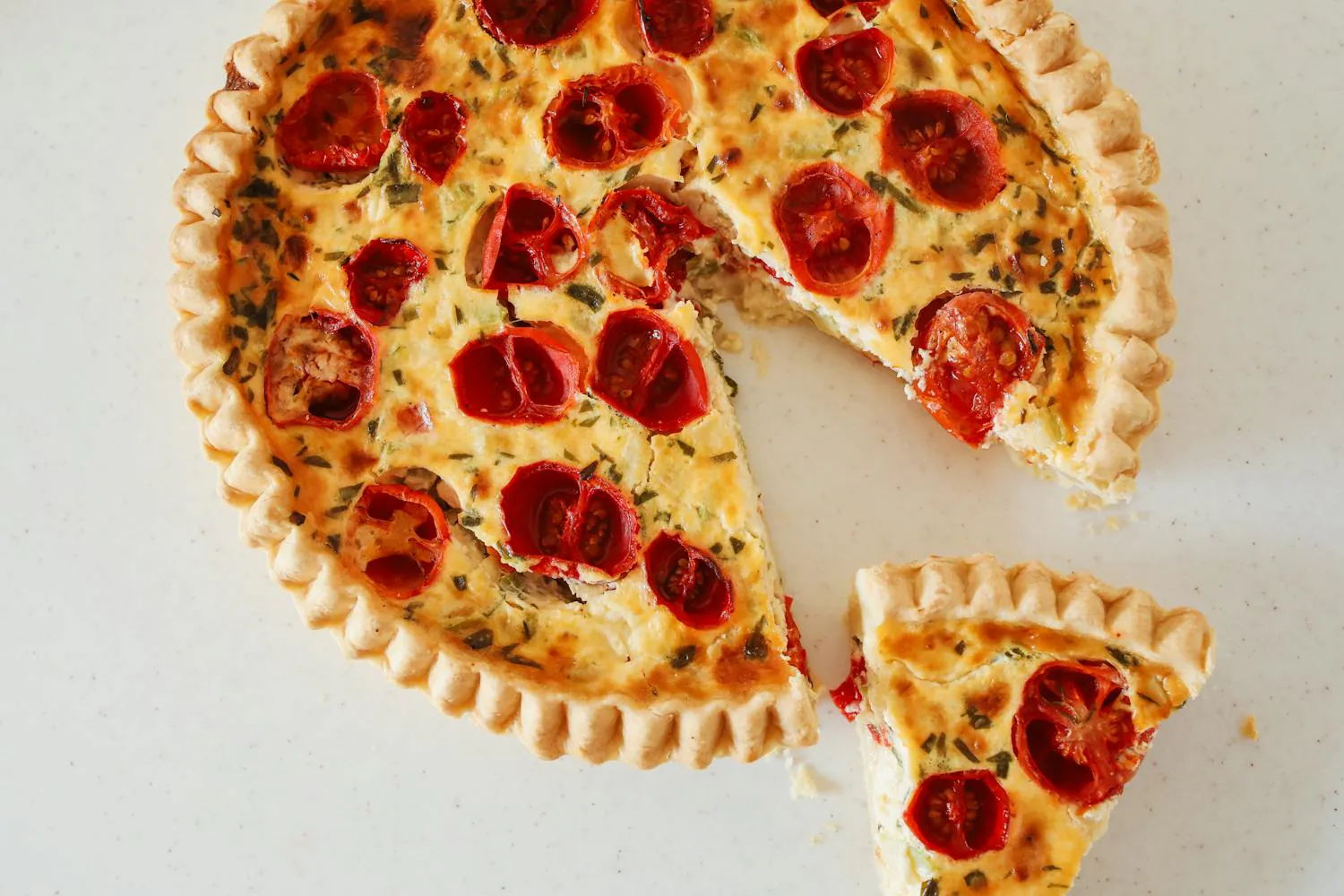 Tomato tart with flaky crust and a slice cut out.